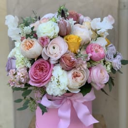 Pink and white rose bouquet in a pink hat box with a satin ribbon