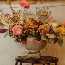 Mixed floral arrangement in a textured gold vase