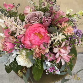 Mixed pink and white floral arrangement in a gold pedestal vase