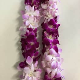 Two purple and pink orchid leis on a light surface