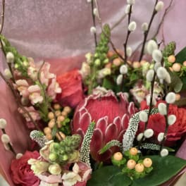 Bouquet with pink protea, roses, and pussy willow stems