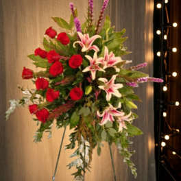 Tall floral spray with red roses and pink lilies on a stand