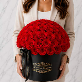 Woman holding a large red rose arrangement in a black hat box