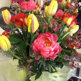Bouquet of yellow and red tulips with a pink peony