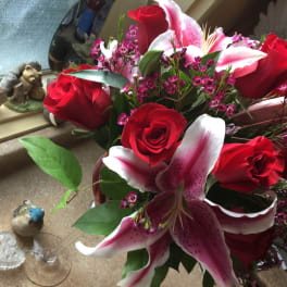 Bouquet of red roses and pink lilies with small purple filler flowers
