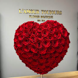 Heart-shaped arrangement of red roses on a stand
