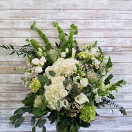 White and green floral arrangement in a clear glass vase