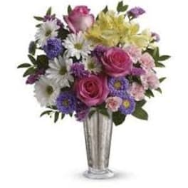 Mixed bouquet of pink roses and purple daisies in a silver vase