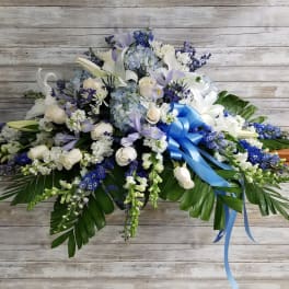 Large white and blue floral spray with a blue ribbon