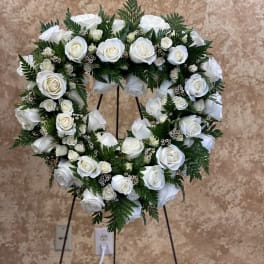 Heart-shaped wreath of white roses on a stand