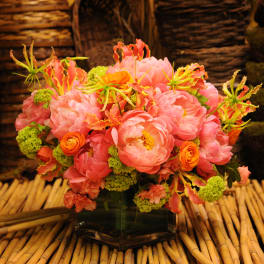 Pink and orange floral arrangement in a glass vase