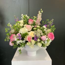 Mixed pink, white, and purple flower arrangement in a white vase