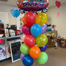 A large birthday balloon bouquet with a "Happy Birthday" foil balloon