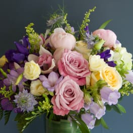 Bouquet of pink, yellow, and purple flowers in a glass vase
