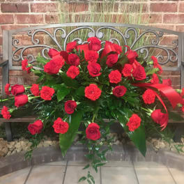 Red rose and carnation arrangement on a bench