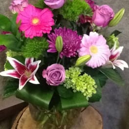Mixed bouquet of pink and purple flowers in a glass vase