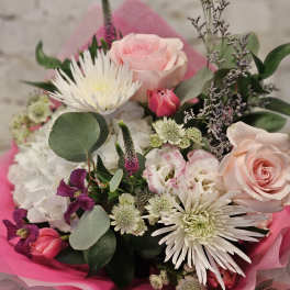Bouquet of pink and white flowers wrapped in bright pink paper