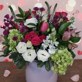 Mixed pink, white, and purple flowers in a round vase