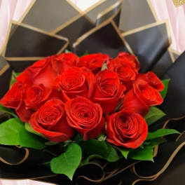 Bouquet of red roses wrapped in black paper with gold trim