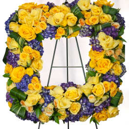 Yellow and purple floral wreath on a metal stand