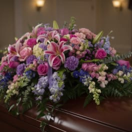 Large casket spray with pink, purple, and white flowers