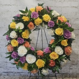 Circular wreath of multicolored roses on a metal stand
