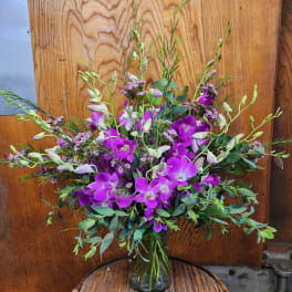 Purple orchid bouquet in a clear glass vase