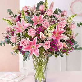 Pink lilies and roses in a clear glass vase