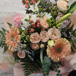 Bouquet of peach roses, gerbera daisies, and white daisies with pink berries