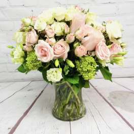 Pink and white roses arranged in a glass vase