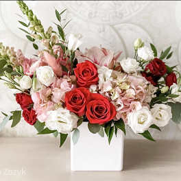 Red and white roses with pink hydrangeas in a white vase