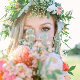 Woman wearing a floral crown and holding a pastel bouquet