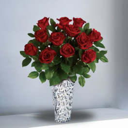 Arrangement of long-stem red roses in a tall textured clear glass vase