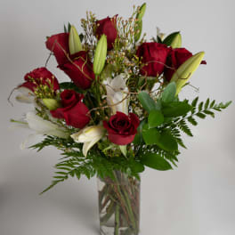 Red roses and white lilies arranged in a clear glass vase