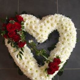 Heart-shaped floral wreath with white flowers and red roses
