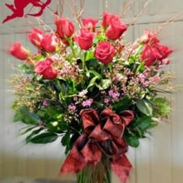 Tall bouquet of pink roses with a large red ribbon
