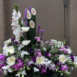 Large floral arrangement with white and purple orchids and white chrysanthemums