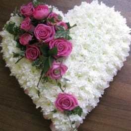 Heart-shaped white floral arrangement with pink roses