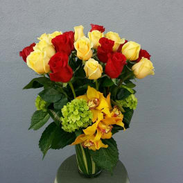 Bouquet of red and yellow roses with yellow orchids in a glass vase