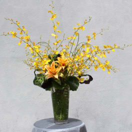 Tall yellow floral arrangement in a clear glass vase