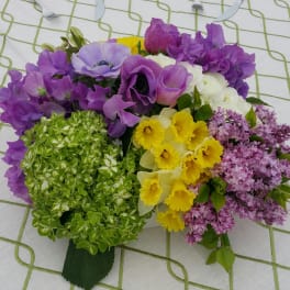 Bouquet of purple, yellow, white, and green flowers on a patterned cloth