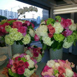 Large floral arrangements with pink roses and white orchids in tall vases