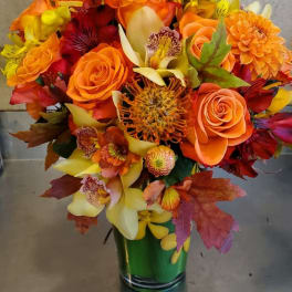 Orange and yellow mixed bouquet in a green vase