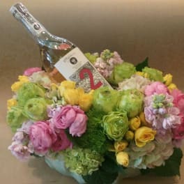 Flower arrangement with a champagne bottle and colorful blooms