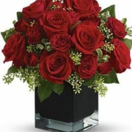 Red roses arranged in a square glass vase