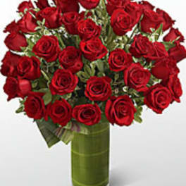 Bouquet of red roses in a tall green glass vase