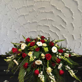 Red and white floral casket spray with roses and daisies