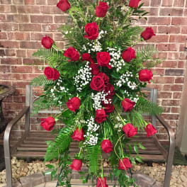 Tall standing arrangement of red roses with white baby's breath