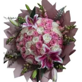 Pink and white rose bouquet with lilies wrapped in mauve paper