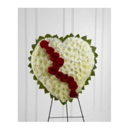 Heart-shaped floral standing spray with red roses on a white chrysanthemum base